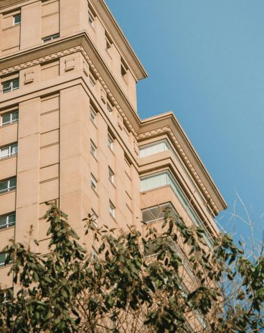 High-rise urban building under a clear blue sky with modern architectural design.